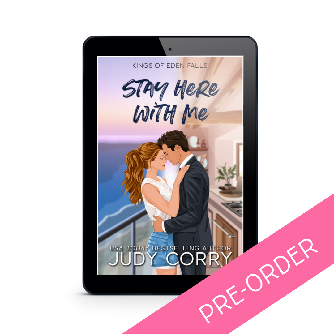 Tablet displaying a book cover with a couple embracing by a window, featuring the text 'Stay Here With Me' by Judy Corry.